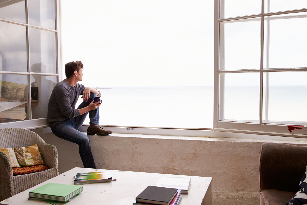 Man Sitting At Window And Looking At Beautiful Beach View