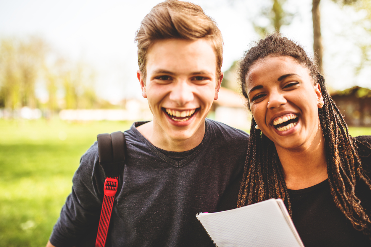 couple of teenagers student outdoors laughing