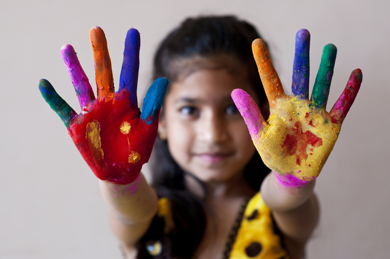 Girl showing colorful painted hands