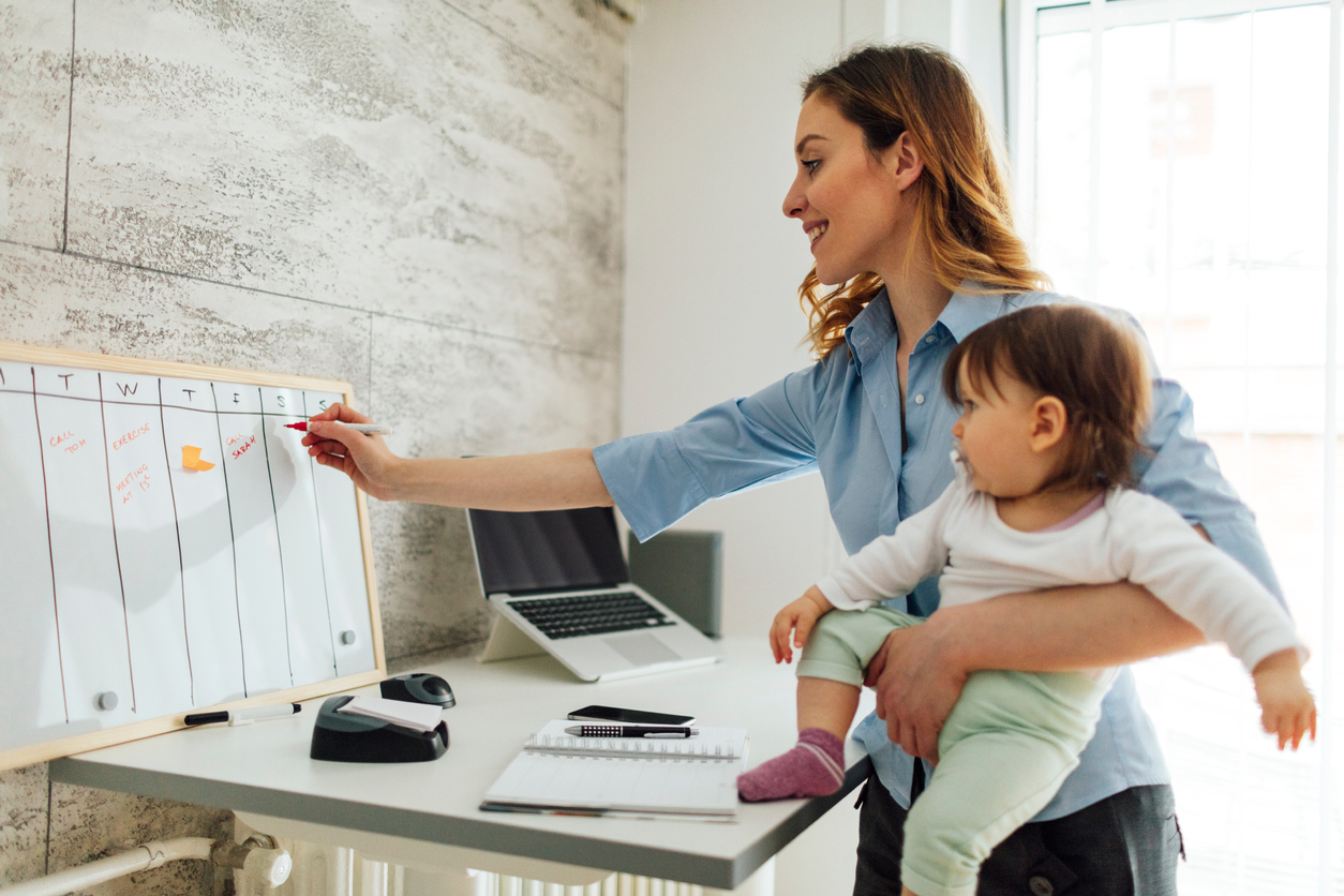 Mother Working From Home And Holding Her Baby