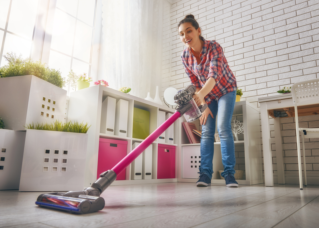 Woman vacuums the floor