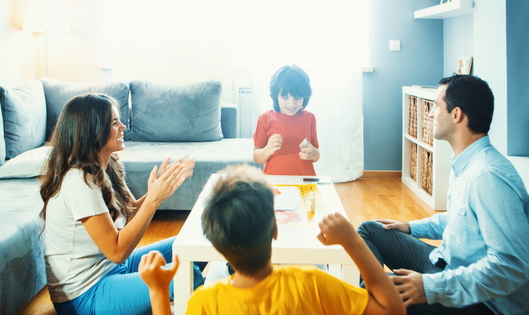 Family playing board game at home.