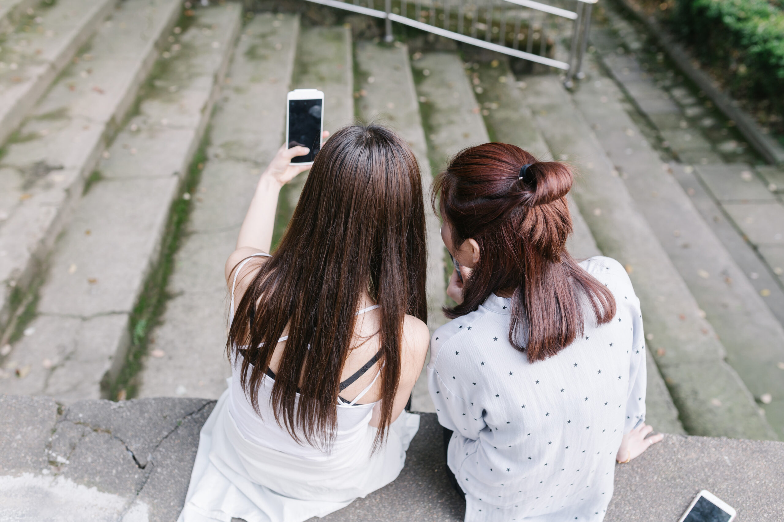 Two girl self portrating with smart phone