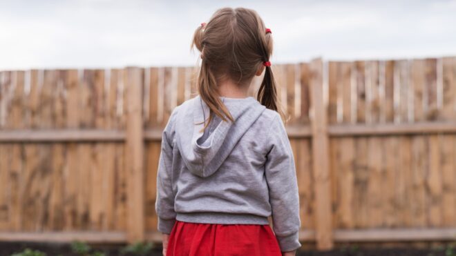 child at fence