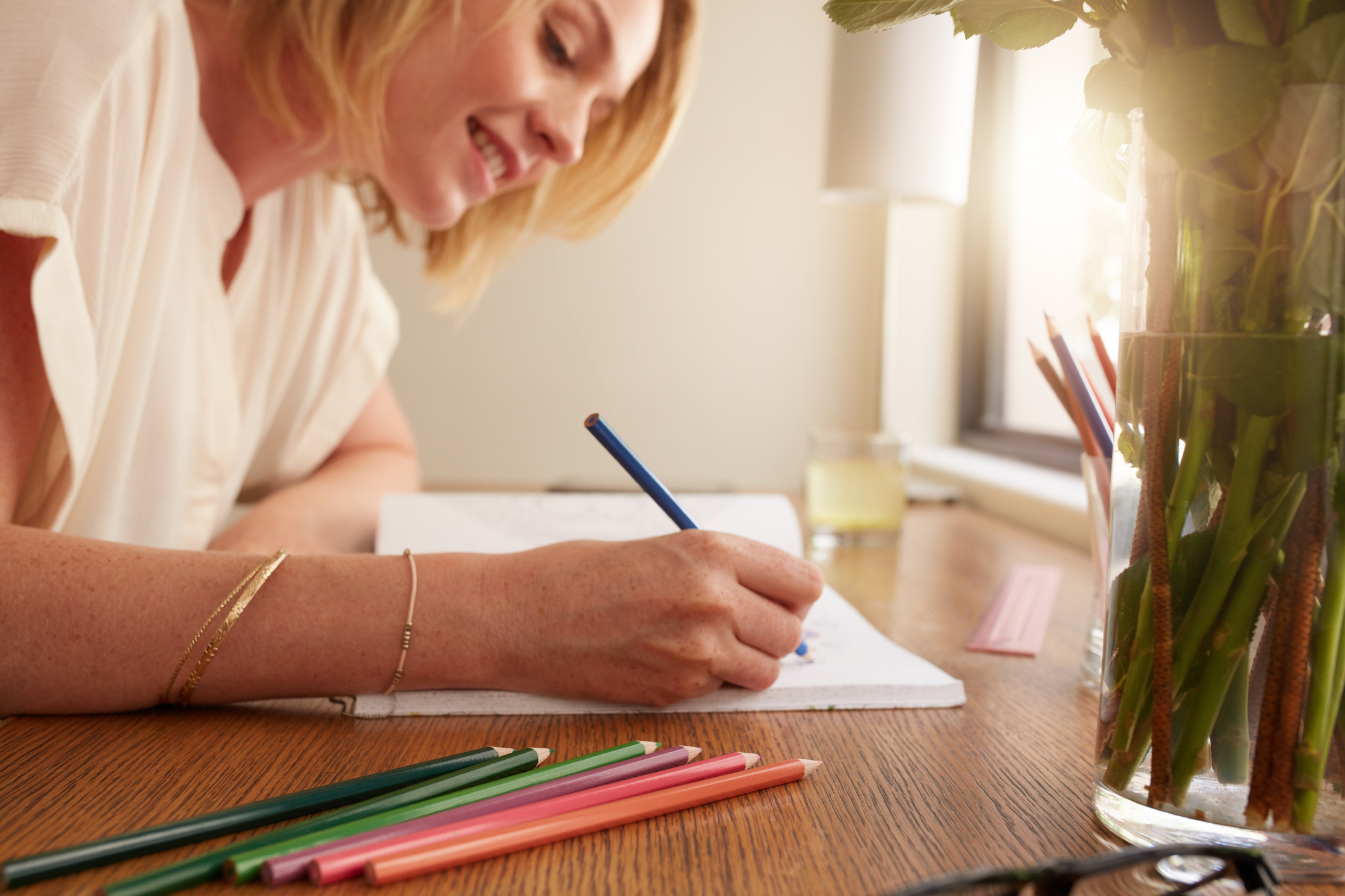 Woman coloring an adult coloring book with pencils