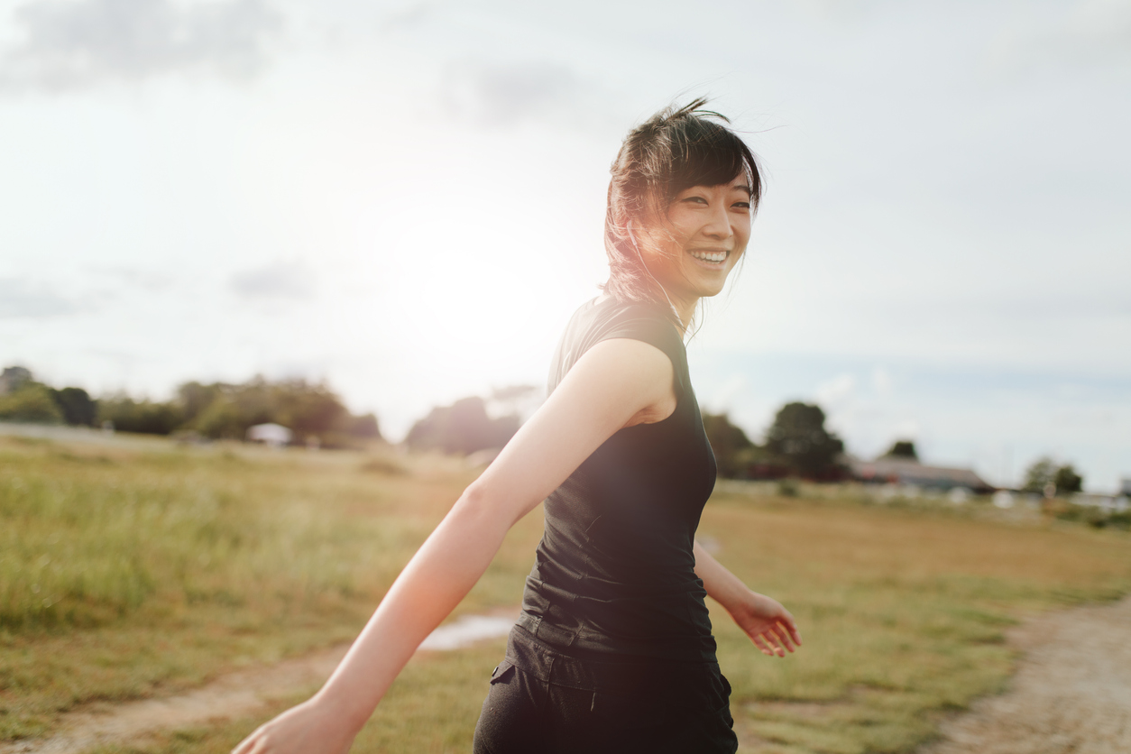 Woman runner walking on field in morning