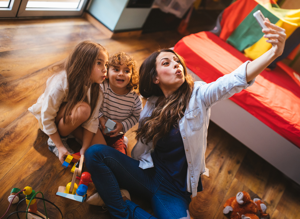 Young mother taking a selfie with her son and daughter