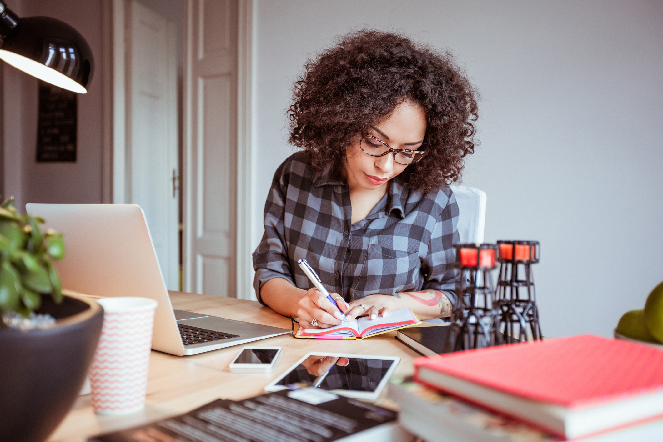 Afro american woman in a home office taking notes