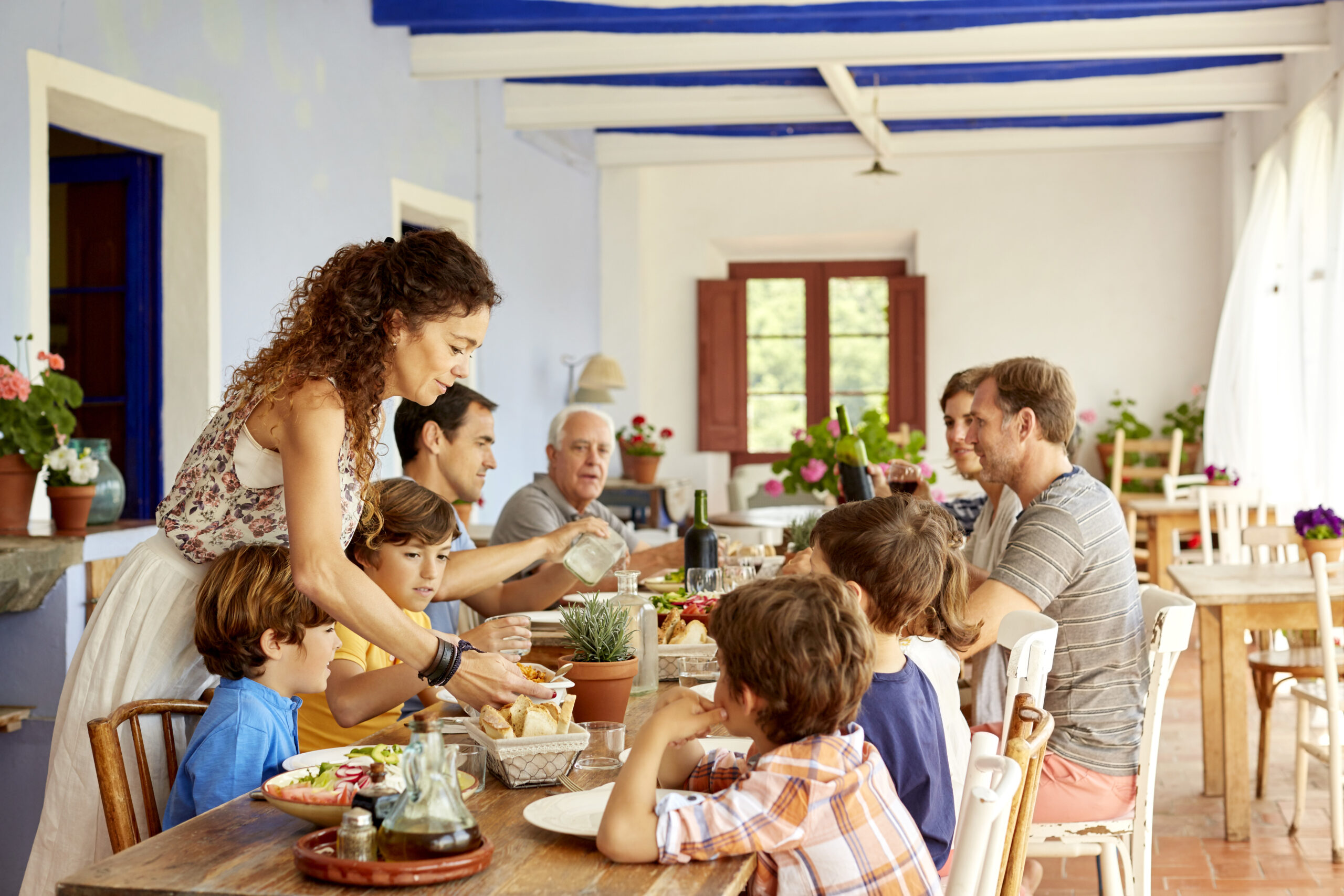 Mother serving food to children at table