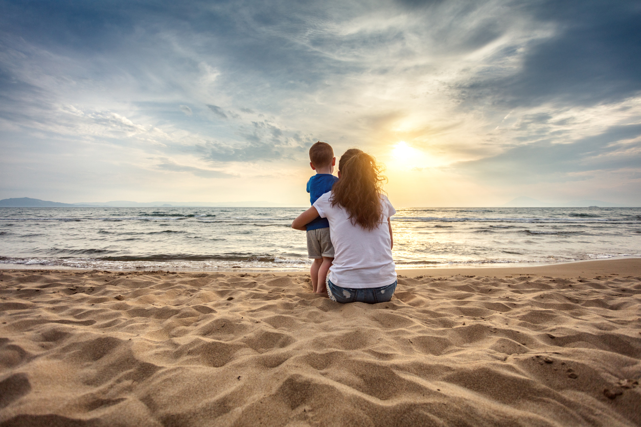 Mother with son enjoying sunset on the beach