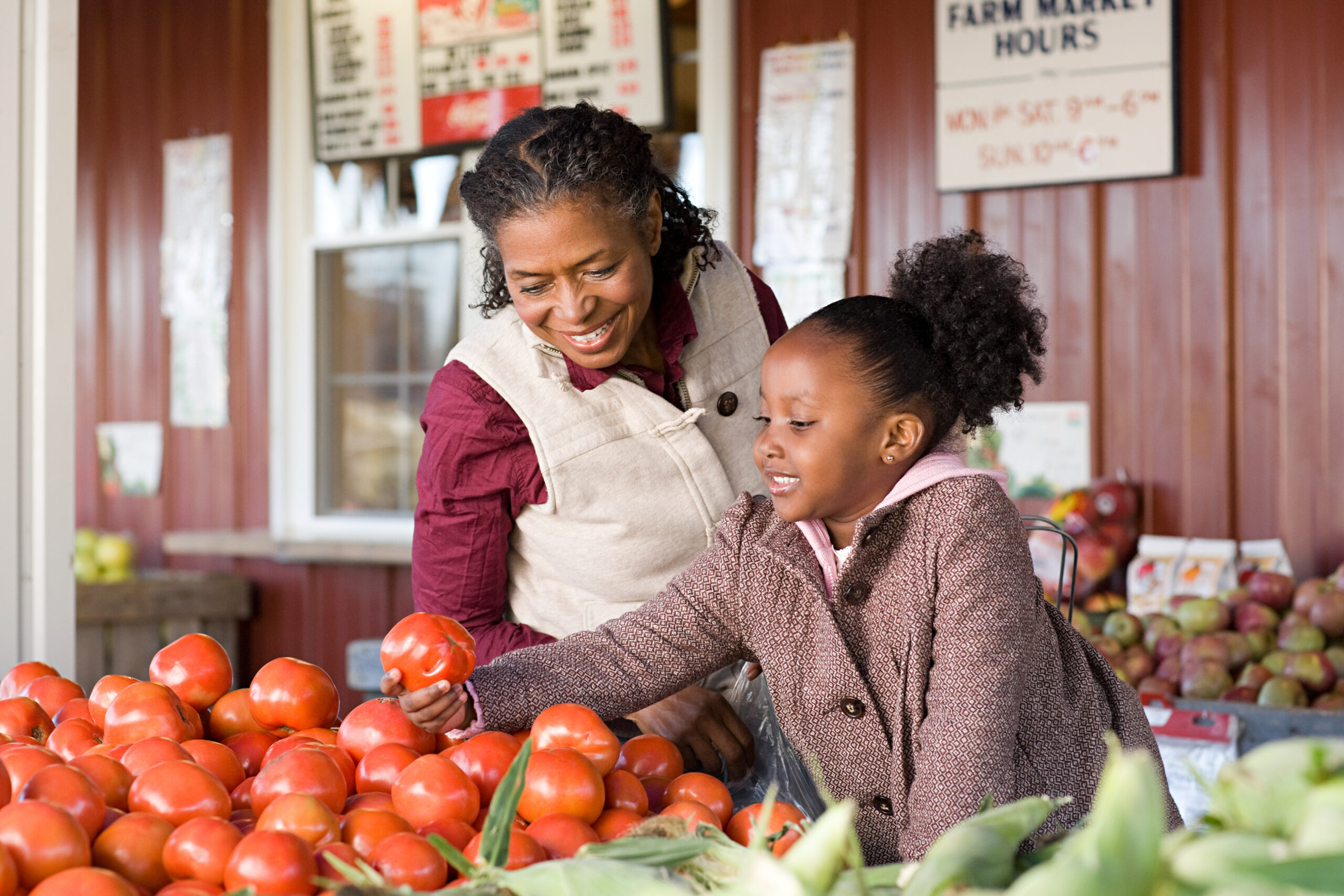 A grandmother and granddaughter choosing tomatoes