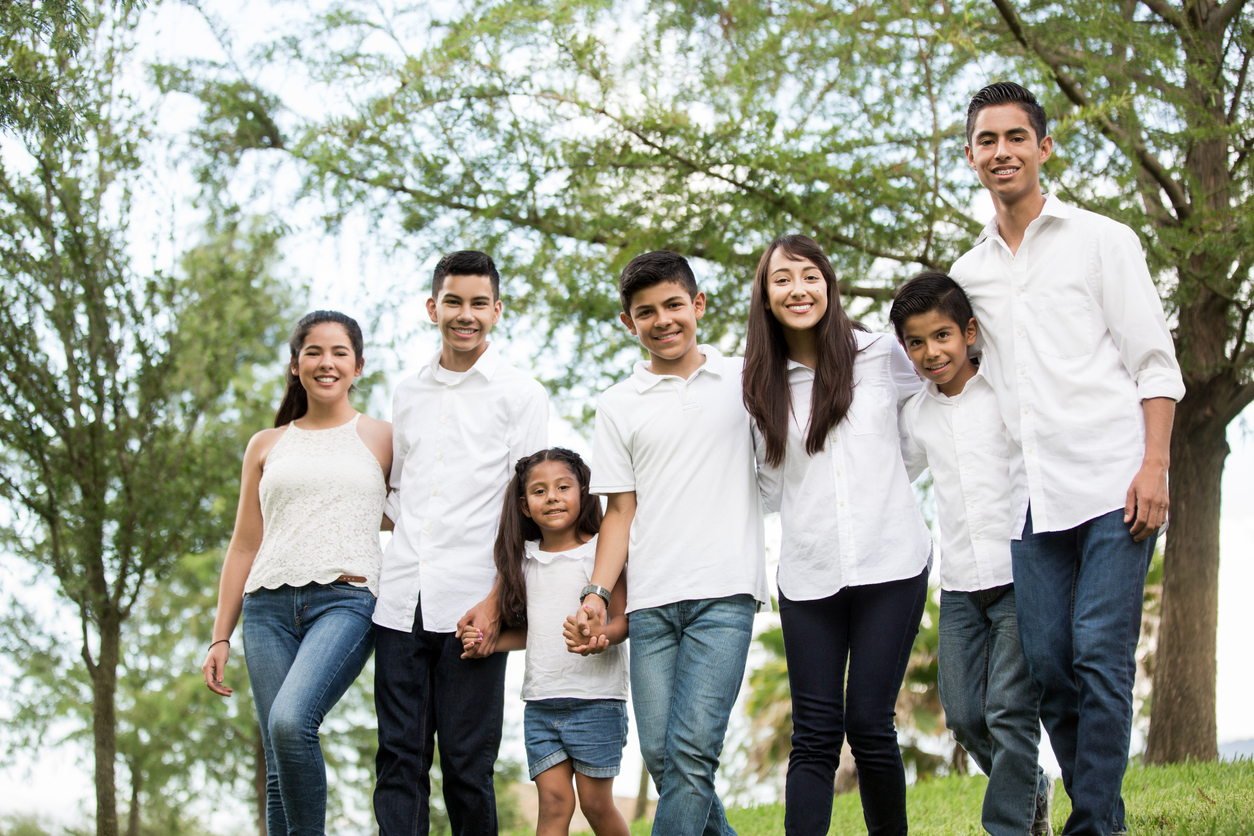 Mixed group of seven latin cousins smiling at camera