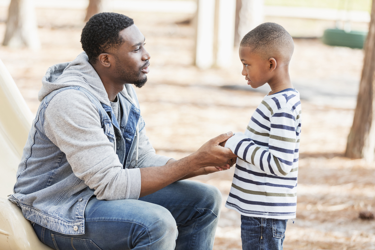 Father talking to little boy on playground