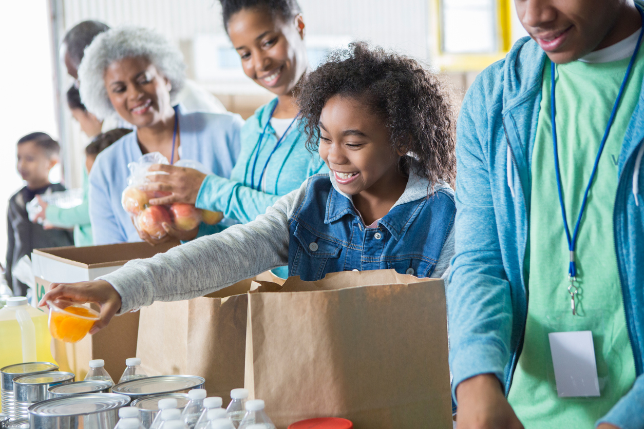 Young girl receives donations while volunteering in food bank