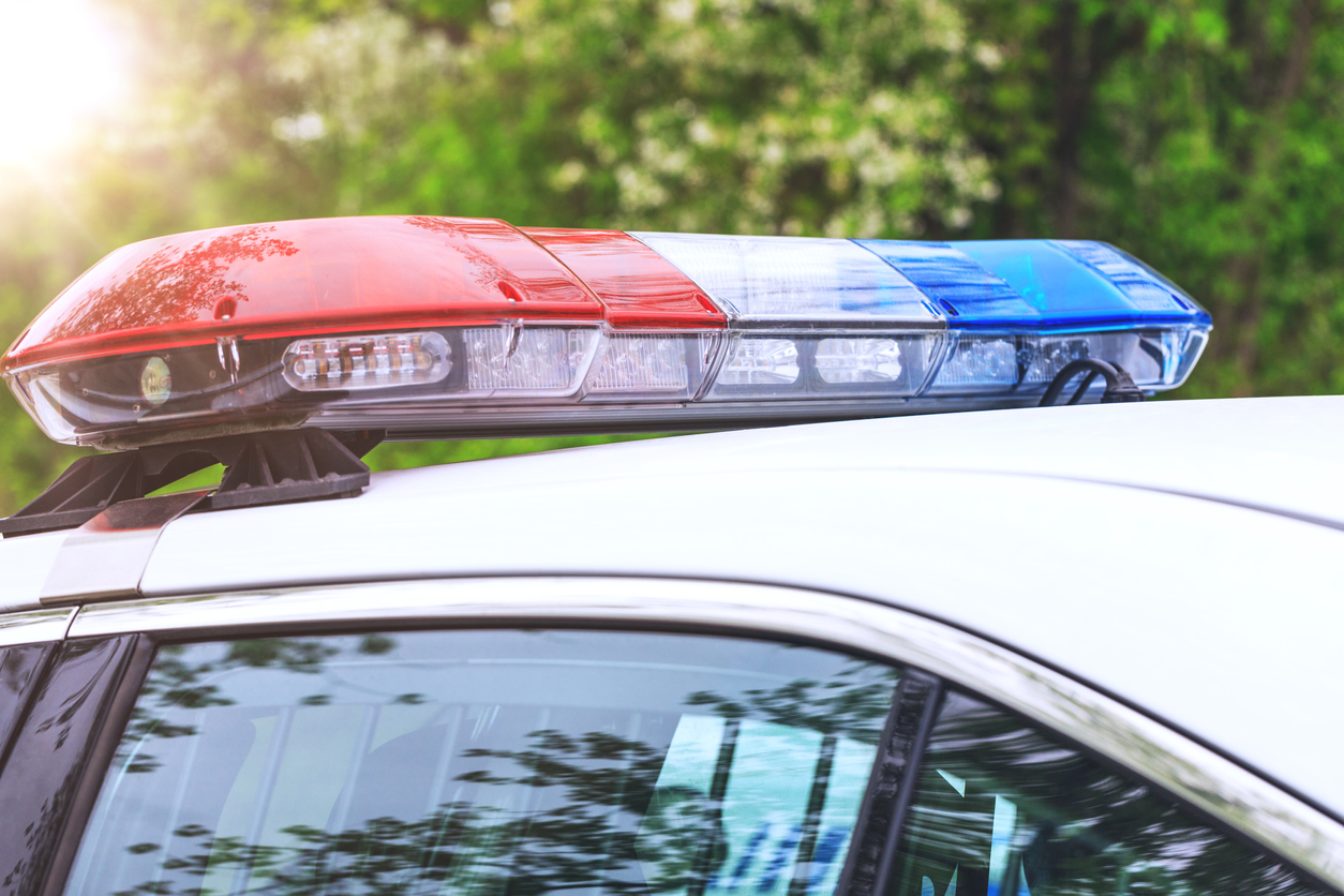 Police patrol car with sirens off during a traffic control. Blue and red flashing sirens of police car during the roadblock in the city.