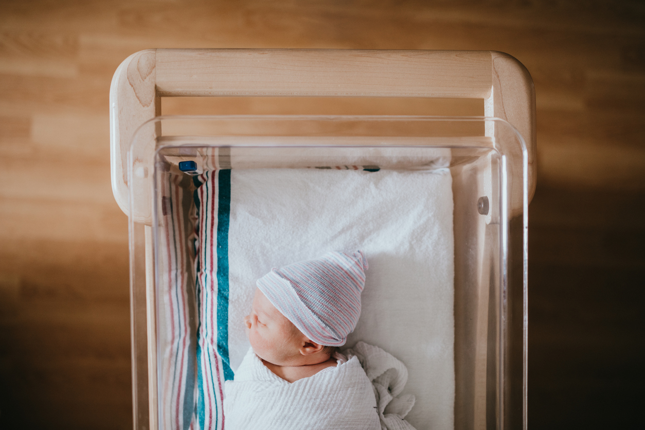 Newborn Baby Sleeping In Hospital Bassinet