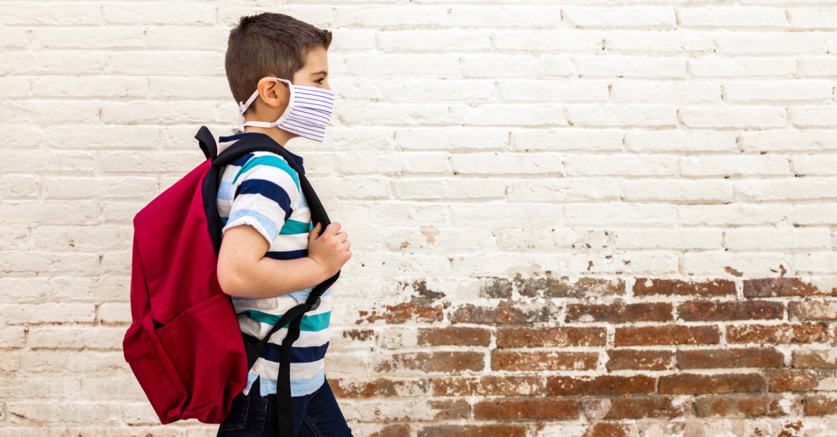 Little boy going to school with protective mask