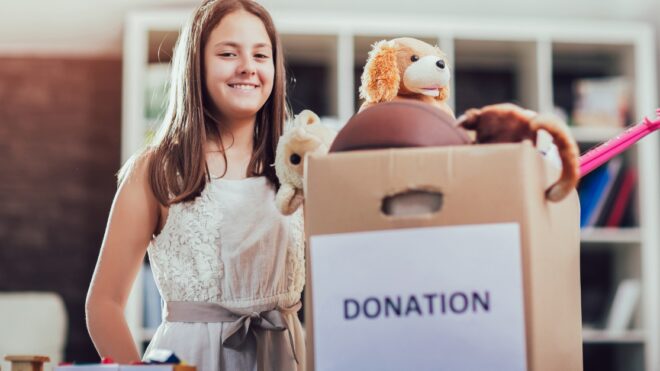 Girl taking donation box full with stuff for donate