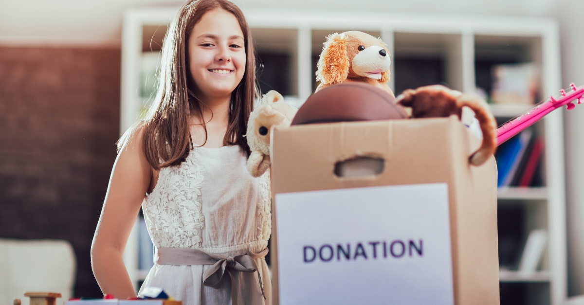 Girl taking donation box full with stuff for donate