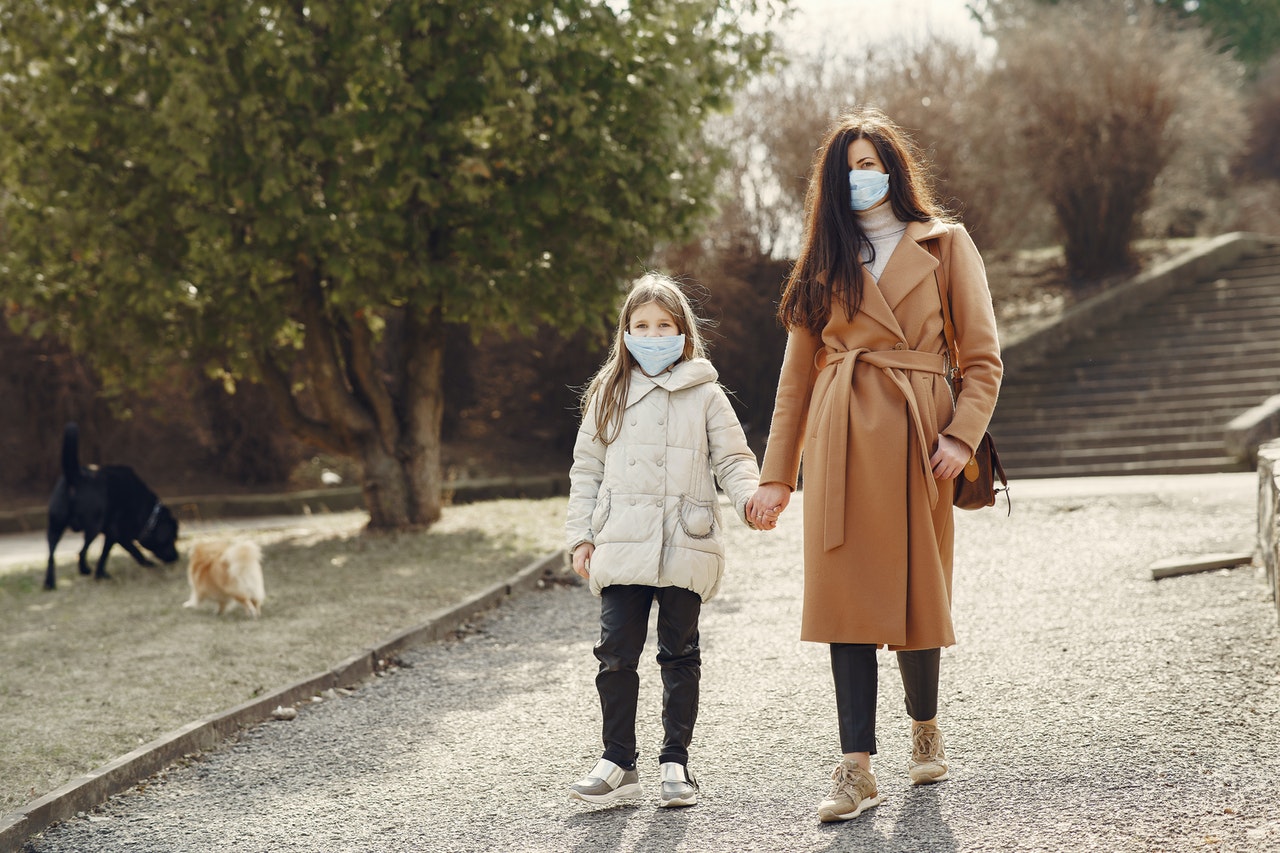 mother-with-daughter-in-face-masks-walking-in-park-4000622-1.jpg