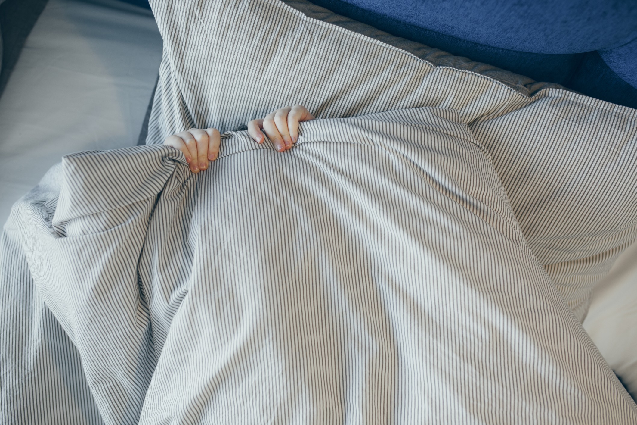 nominated-top-view-of-little-kid-in-bed-covering-his-face-with-striped-blanket-or-coverlet-sleeping_t20_E4XaGJ.jpg