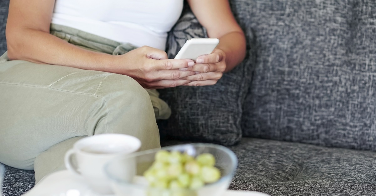 Mature woman with smart phone at home