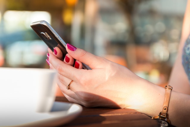 person-holding-a-black-smartphone-wearing-a-brown-leather-160096.jpg