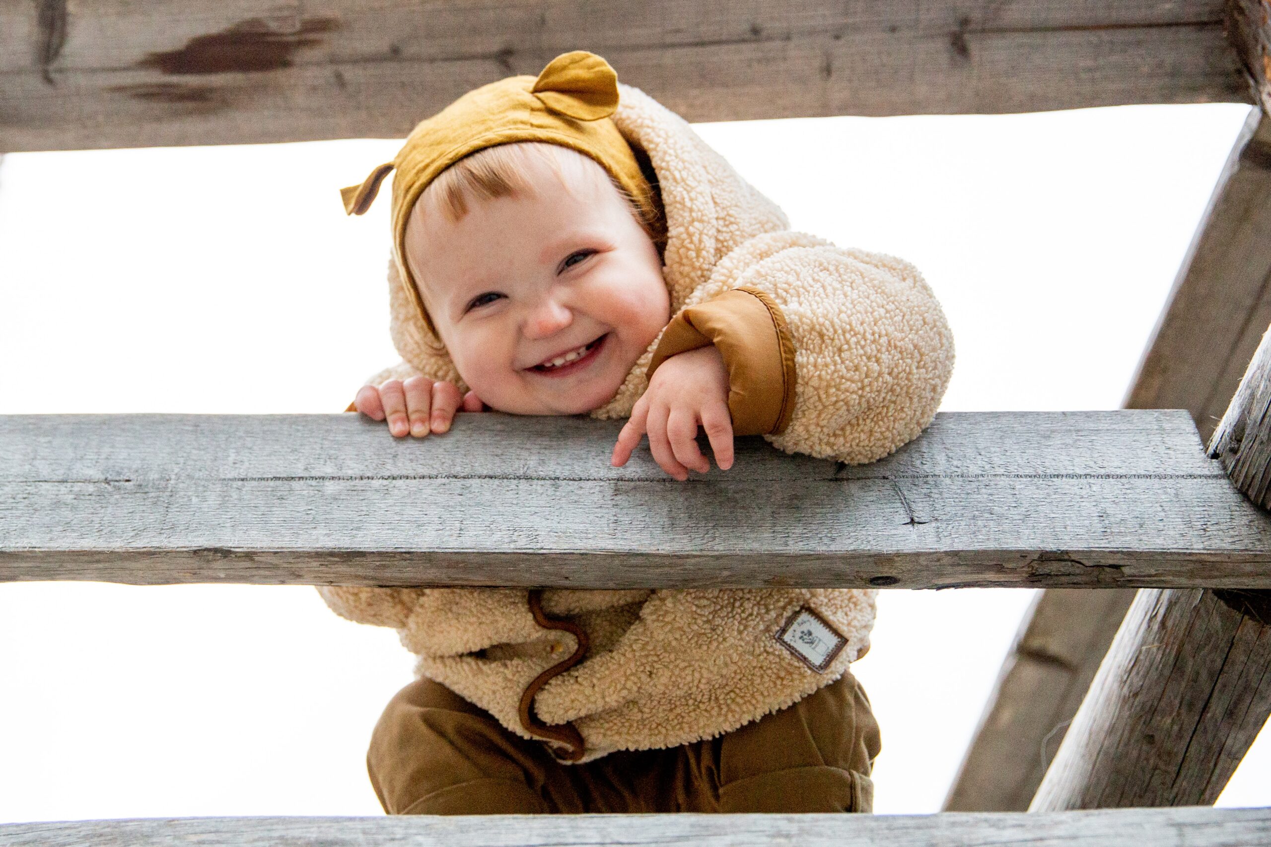 photo-of-baby-leaning-on-wooden-fence-3934003-1.jpg