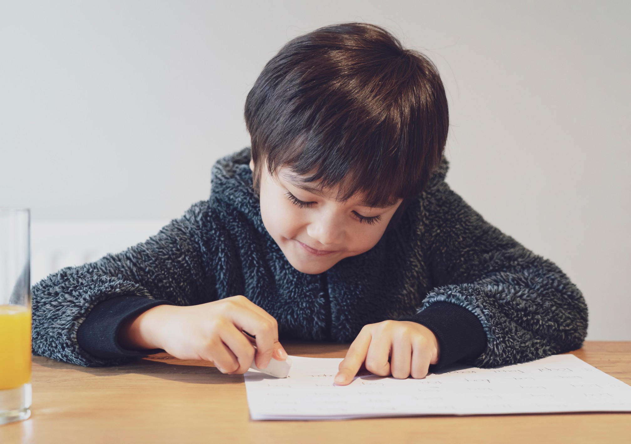 portrait-of-adorable-kid-doing-homework-with-happy-face-female-cute-child-boy-using-rubber-rubbing_t20_axR7N6.jpg