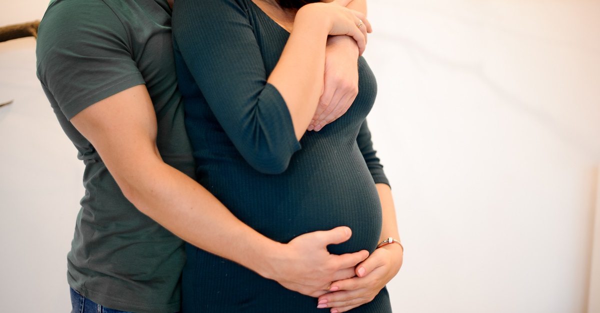 No face portrait of man hugging pregnant woman