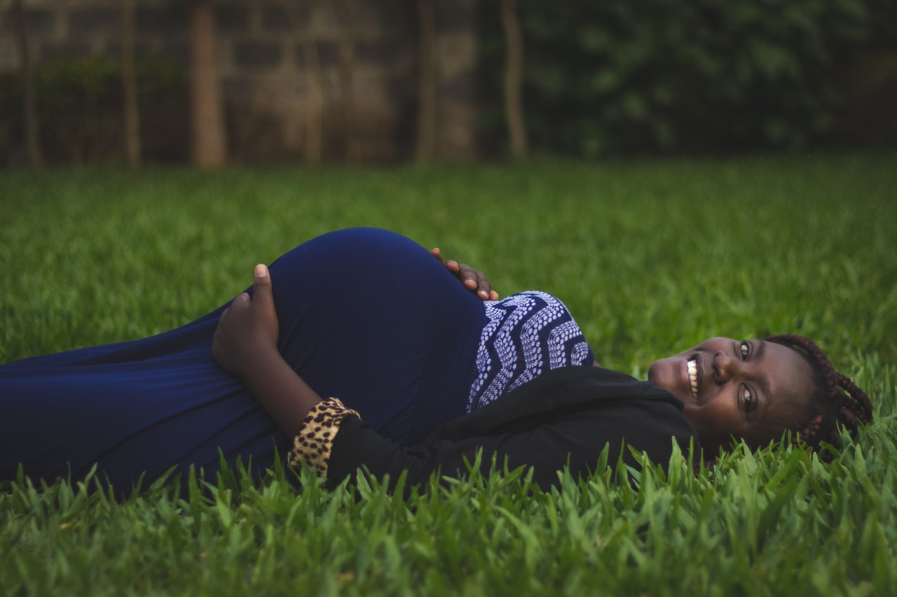 pregnant-woman-lying-on-green-grass-fields-2781219.jpg