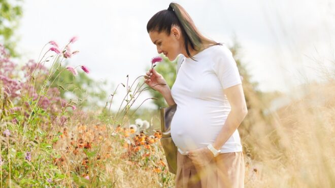 pregnant-woman-smells-flowers