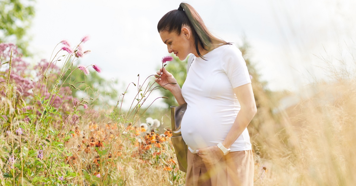 pregnant-woman-smells-flowers