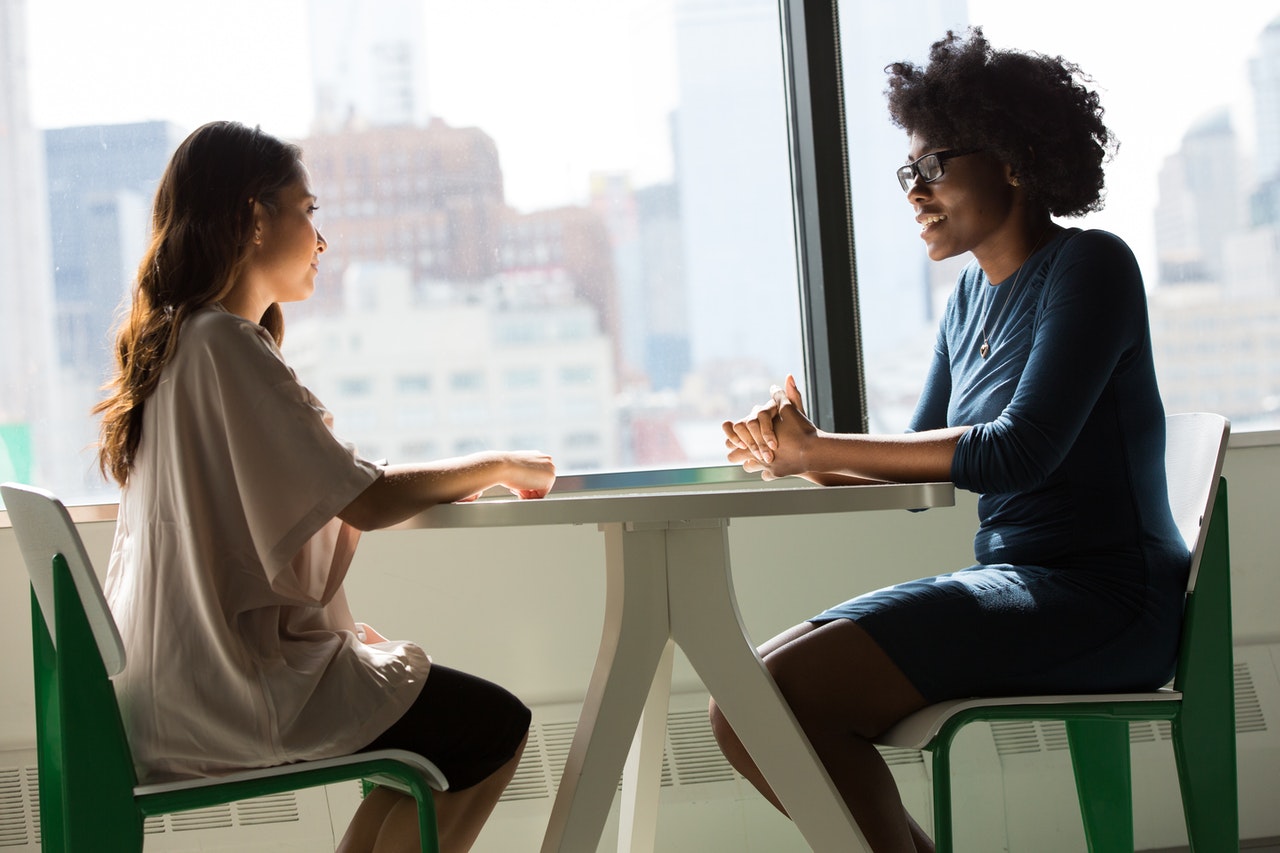 two-women-sitting-on-chairs-beside-window-1181719.jpg