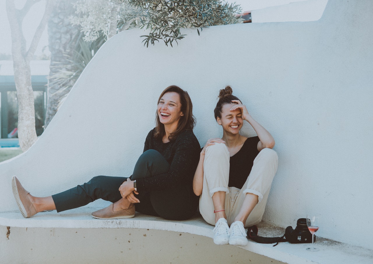 two-women-sitting-on-white-bench-1549280.jpg