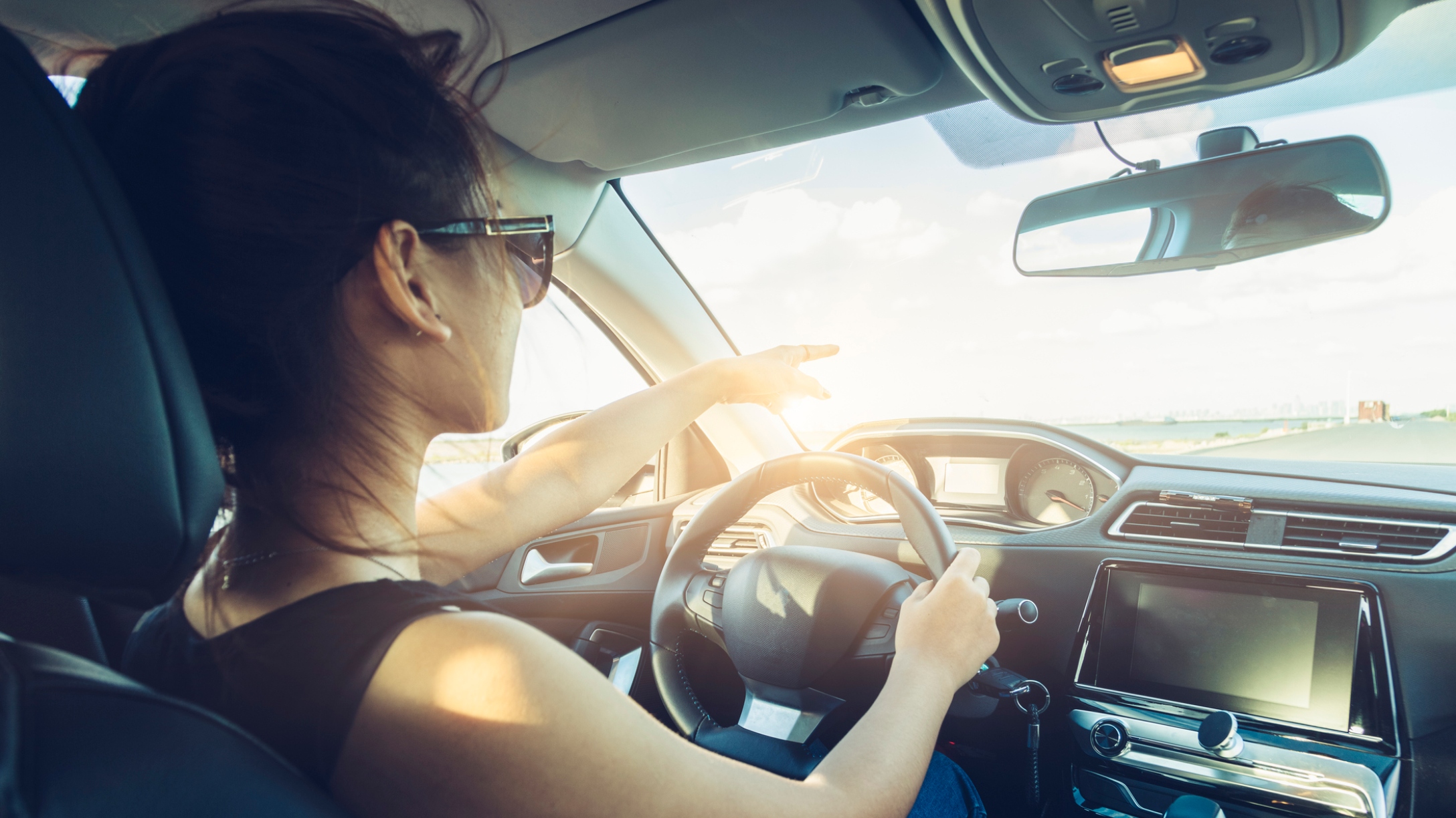 rear view of cool girl in sunglasses driving car.