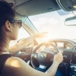 rear view of cool girl in sunglasses driving car.