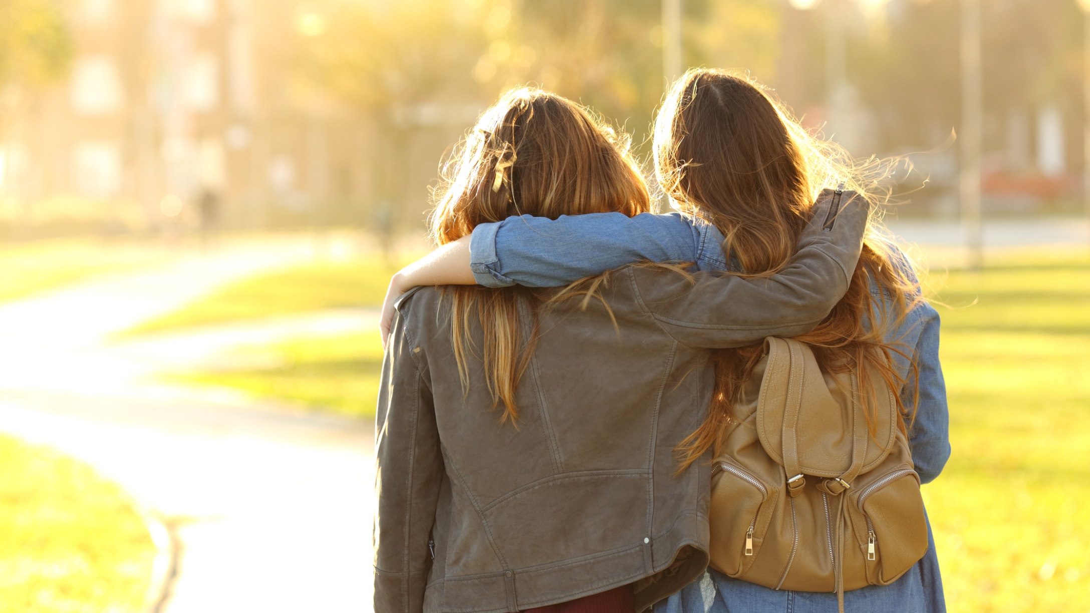 Affectionate friends walking at sunset in a park