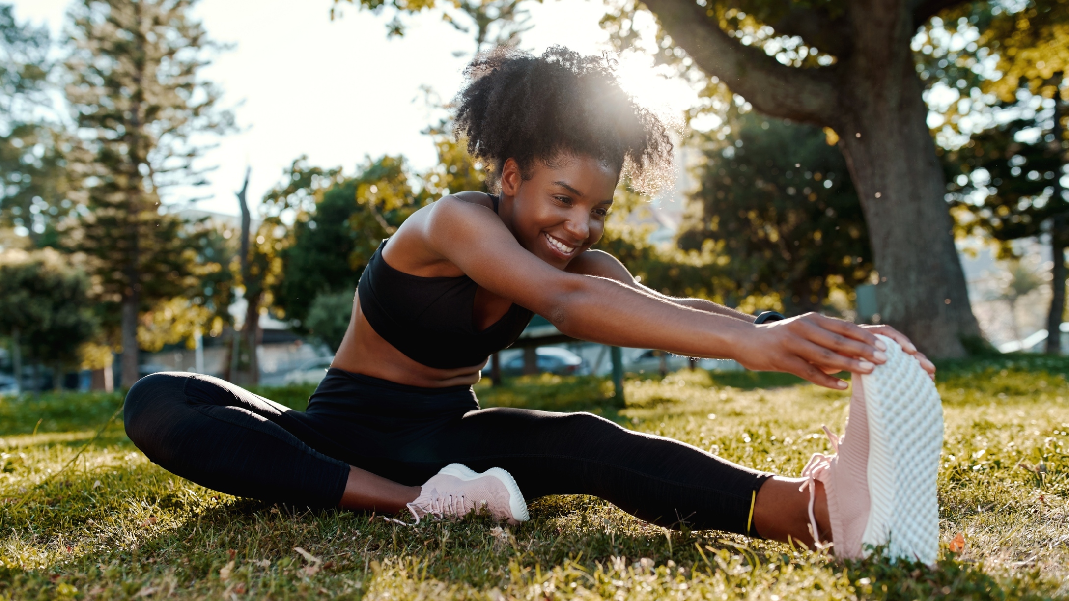 Smiling young woman doing exercise in the park