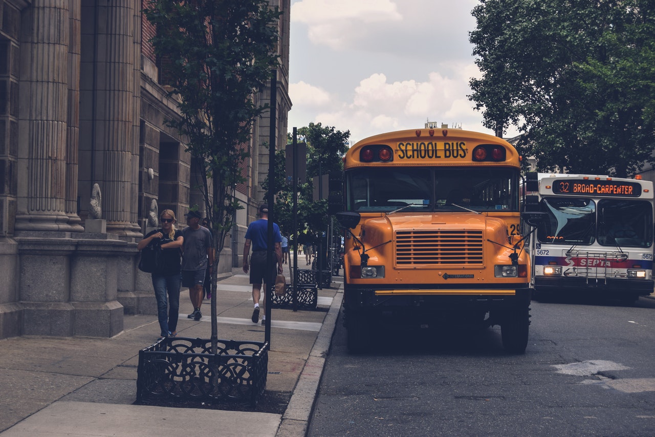 yellow-school-bus-beside-gray-concrete-building-1386484.jpg