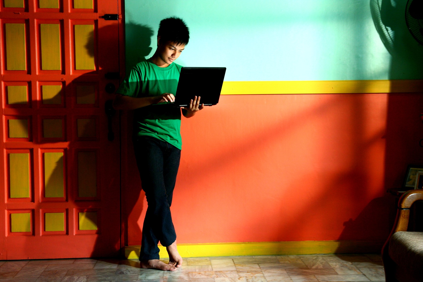 young-asian-teen-with-a-laptop-computer-in-a-living-room_t20_pJ0njj.jpg