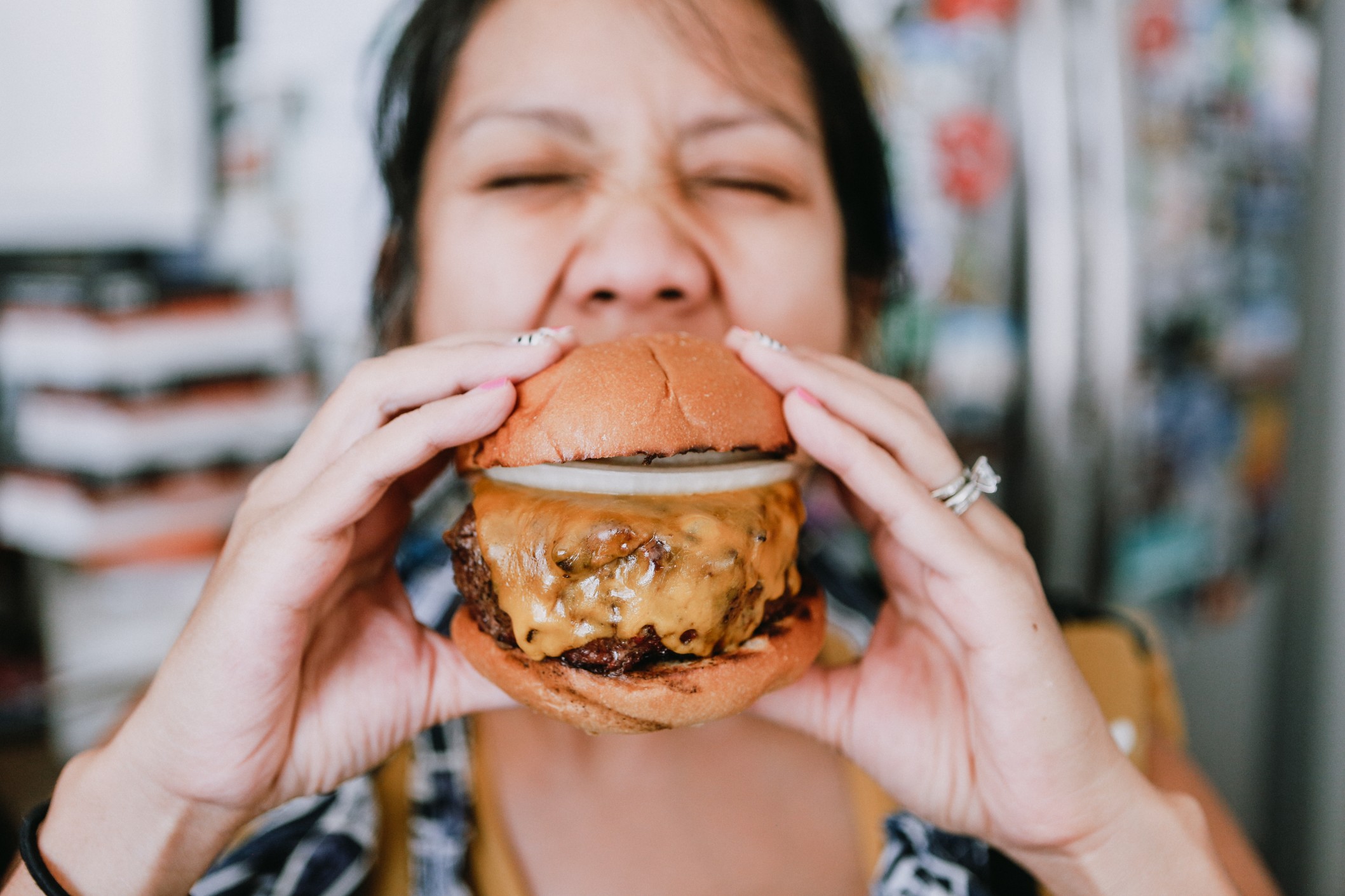 young-millennial-woman-taking-a-bite-out-of-a-juicy-cheeseburger_t20_a7JxBE.jpg