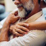 Older man being embraced