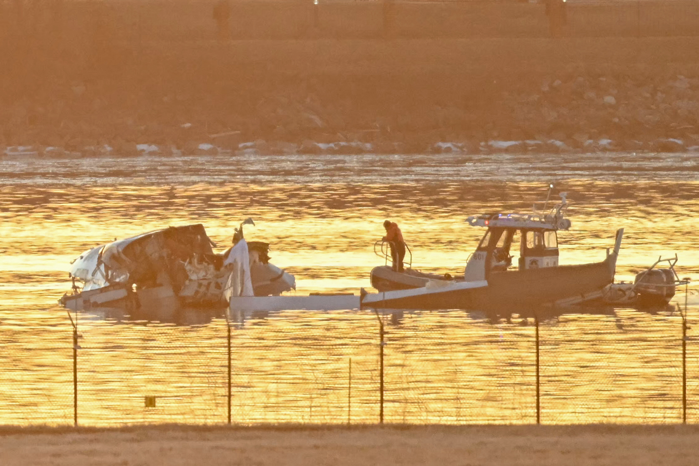 Part of the wreckage is seen as rescue boats search the waters of the Potomac River American Airlines flight 5342 on approach to Reagan National Airport crashed into the river near Washington, DC, on January 30, 2025. A regional jet from Kansas crashed into Washington's Potomac River after colliding mid-air with a military helicopter near Reagan National Airport, officials said January 29, prompting a major emergency response and grounding all flights. (Photo by Andrew CABALLERO-REYNOLDS / AFP) (Photo by ANDREW CABALLERO-REYNOLDS/AFP via Getty Images)