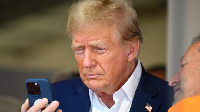 MIAMI, FLORIDA - MAY 05: Donald Trump talks on the phone in the McLaren garage prior to the F1 Grand Prix of Miami at Miami International Autodrome on May 05, 2024 in Miami, Florida. (Photo by Clive Mason/Getty Images)