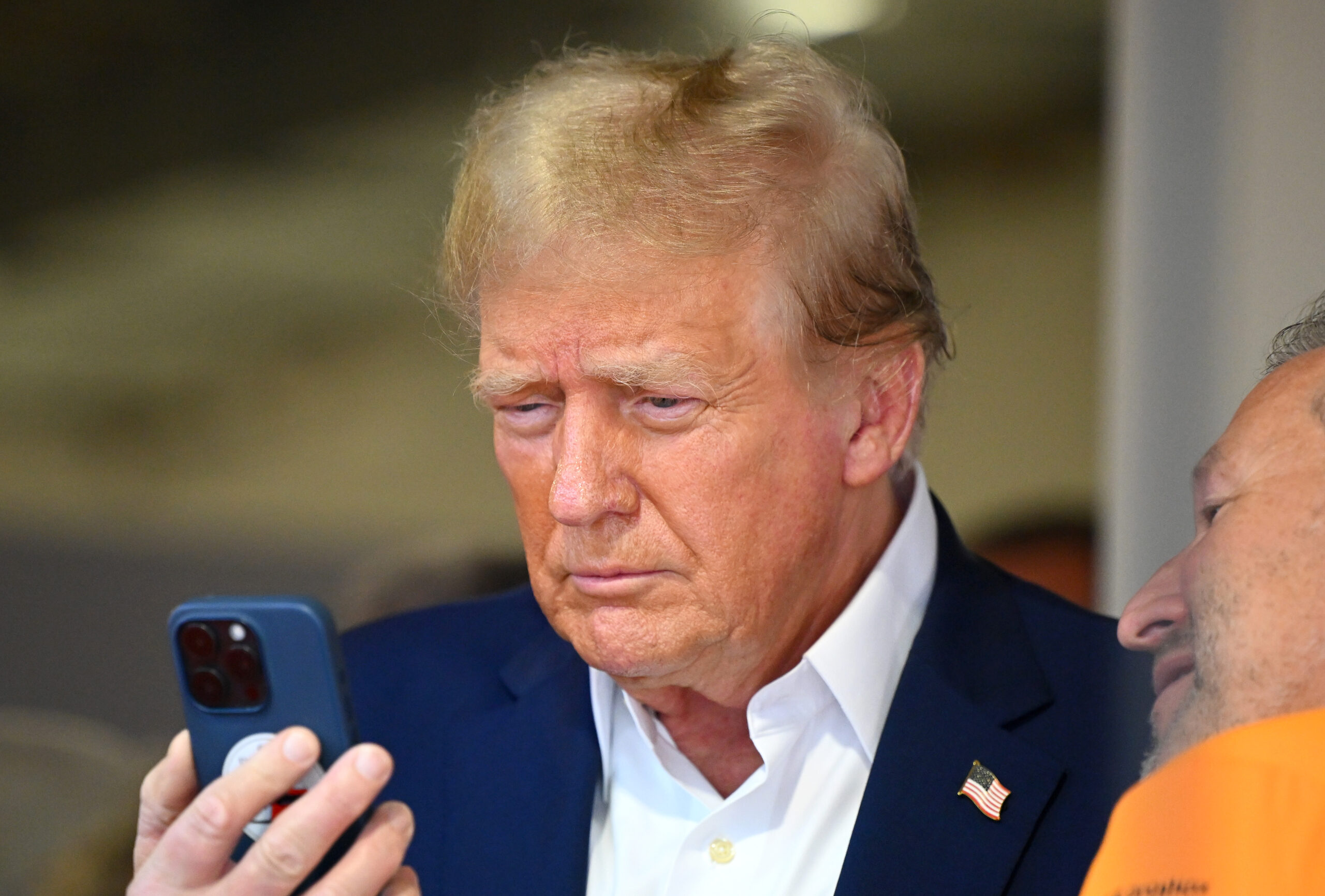 MIAMI, FLORIDA - MAY 05: Donald Trump talks on the phone in the McLaren garage prior to the F1 Grand Prix of Miami at Miami International Autodrome on May 05, 2024 in Miami, Florida. (Photo by Clive Mason/Getty Images)