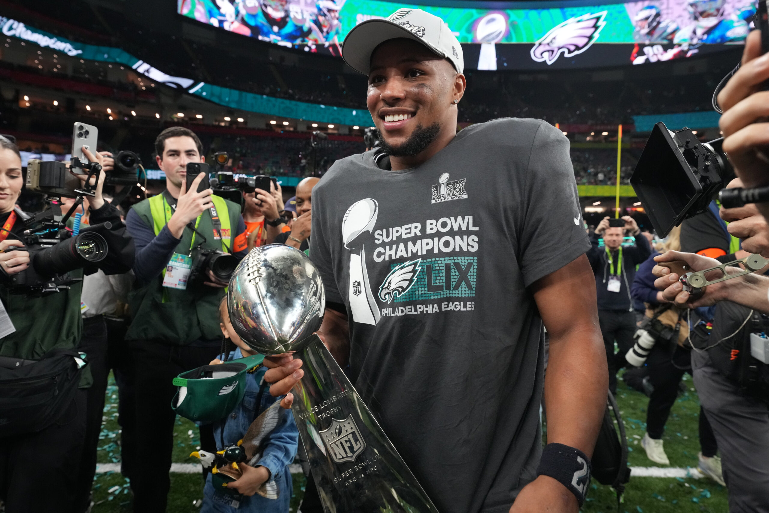 Football: Super Bowl LIX: Philadelphia Eagles Saquon Barkley (26) in action, victorious with the Vince Lombardi trophy following game vs Kansas City Chiefs at Caesar's Superdome.