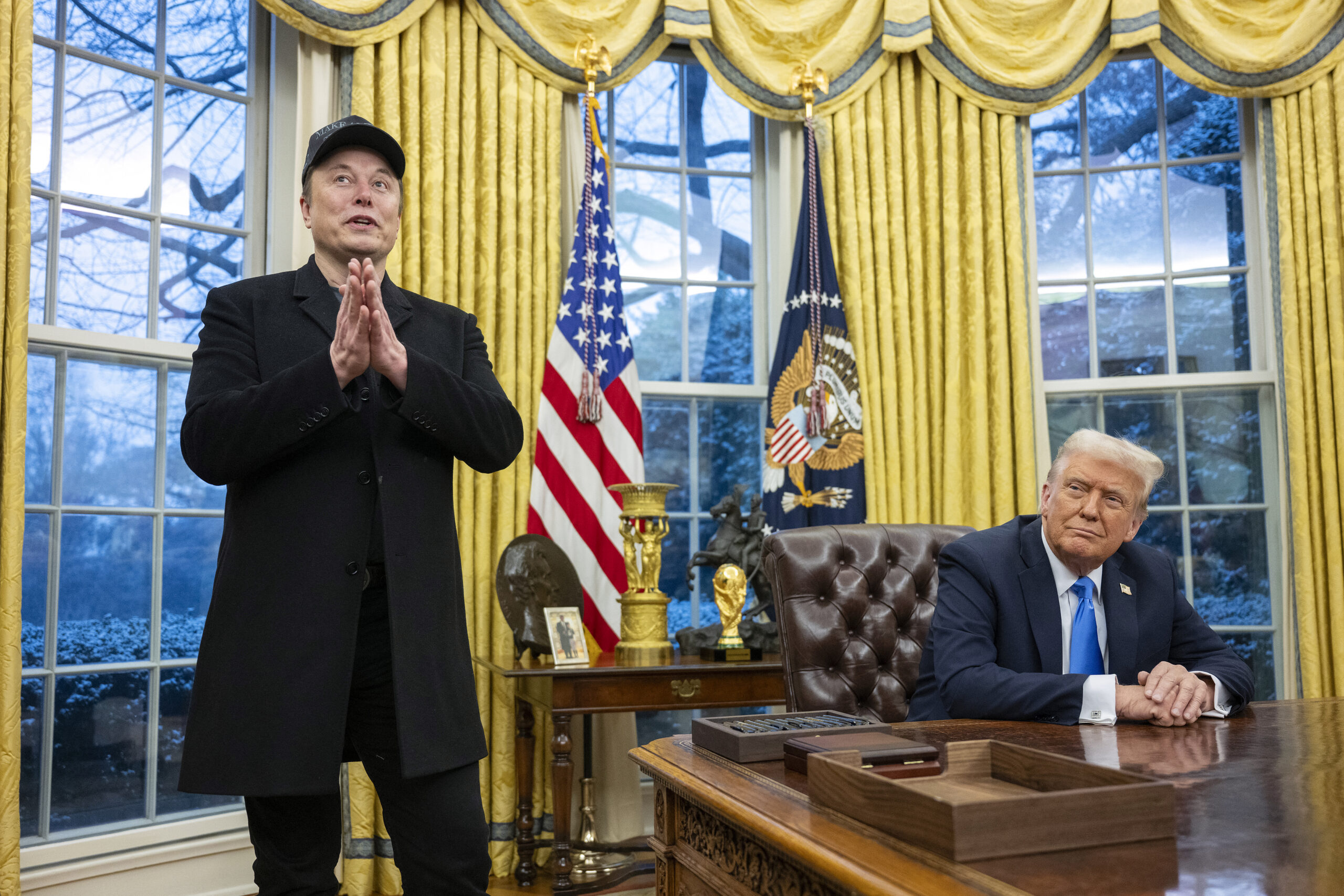 Elon Musk speaks as US President Donald Trump looks on in the Oval Office of the White House in Washington, DC, on February 11, 2025. Tech billionaire Elon Musk, who has been tapped by President Donald Trump to lead federal cost-cutting efforts, said the United States would go "bankrupt" without budget cuts. Musk leads the efforts under the newly created Department of Government Efficiency (DOGE), and was speaking at the White House with Trump, who has in recent weeks unleashed a flurry of orders aimed at slashing federal spending. (Photo by Jim WATSON / AFP) (Photo by JIM WATSON/AFP via Getty Images)