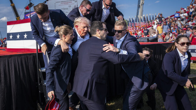 Butler, PA - July 13 : U.S. Secret Service agents remove Republican presidential candidate former president Donald Trump from the stage with blood on his face during a campaign rally at Butler Farm Show Inc. in Butler, PA on Saturday, July 13, 2024. Trump later shared that a bullet pierced part of his ear during the assassination attempt. (Photo by Jabin Botsford/The Washington Post via Getty Images)