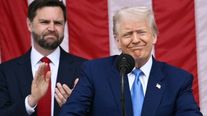 U.S. President Donald Trump delivers remarks as U.S. Vice President JD Vance looks on at the National Memorial Day Observance at the Memorial Amphitheatre in Arlington National Cemetery in Arlington, Virginia, on Monday, May 26, 2025. (Brendan Smialowski/AFP/Getty Images/TNS)